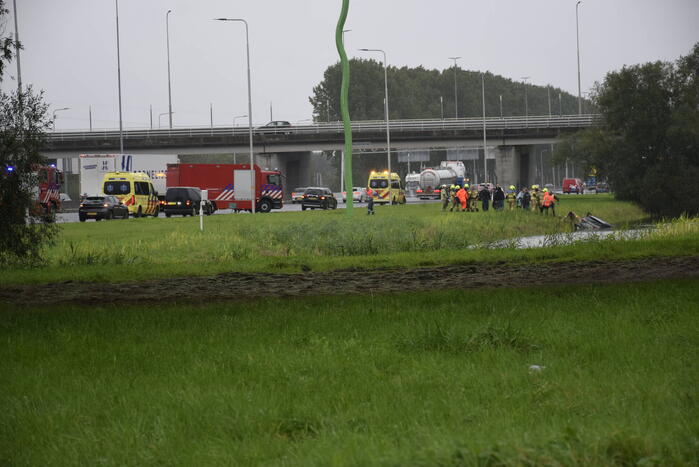 Auto raakt te water naast snelweg