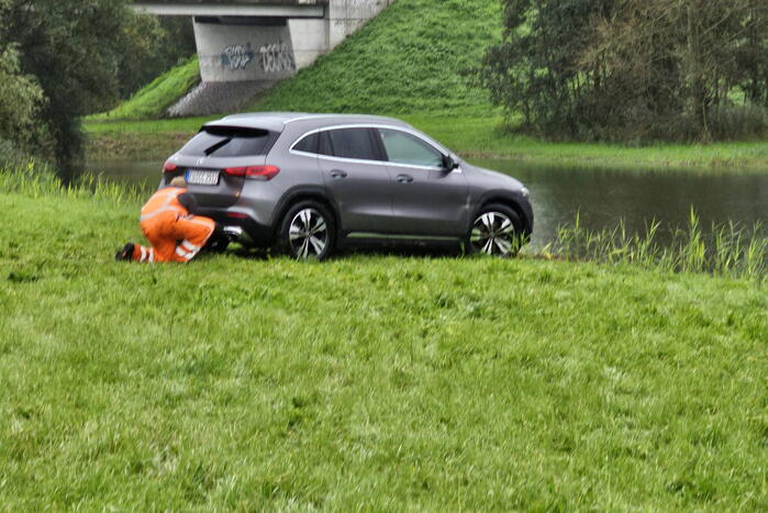 Auto raakt te water naast snelweg