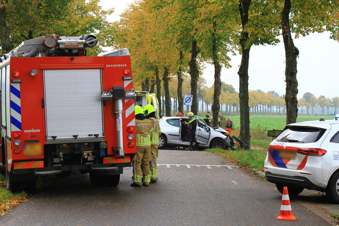 Bestuurder bekneld bij botsing tegen boom