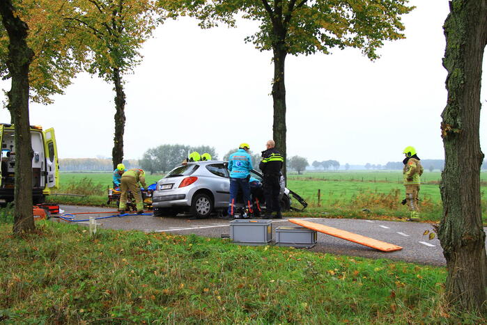 Bestuurder bekneld bij botsing tegen boom