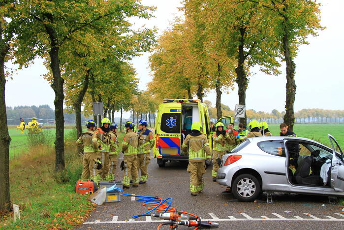 Bestuurder bekneld bij botsing tegen boom