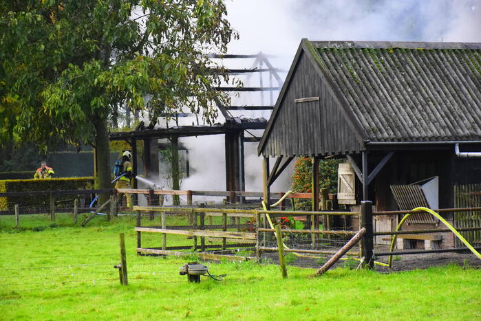 Grote brand in loods dreigt over te slaan naar woning