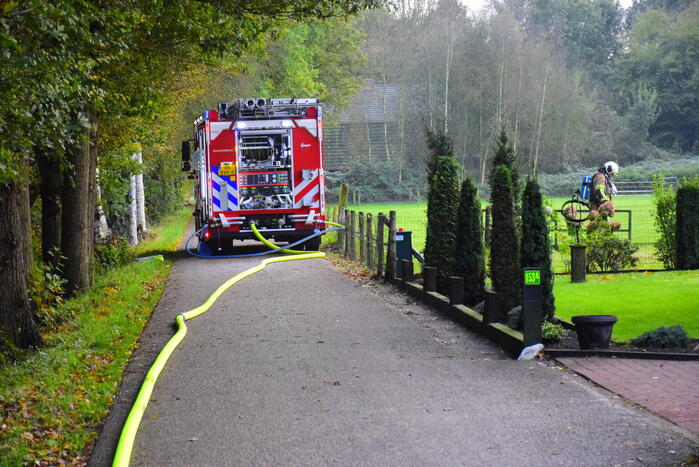 Grote brand in loods dreigt over te slaan naar woning