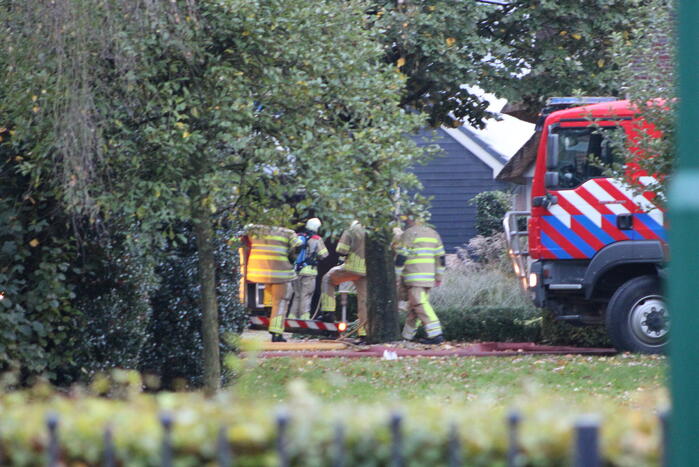 Grote brand in loods dreigt over te slaan naar woning