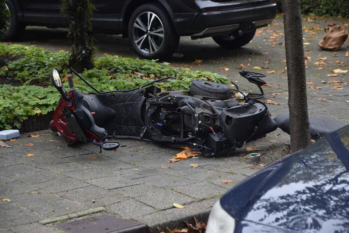 Overstekende scooter geschept door auto