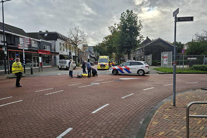 Persoon op scooter onderuit op kruising