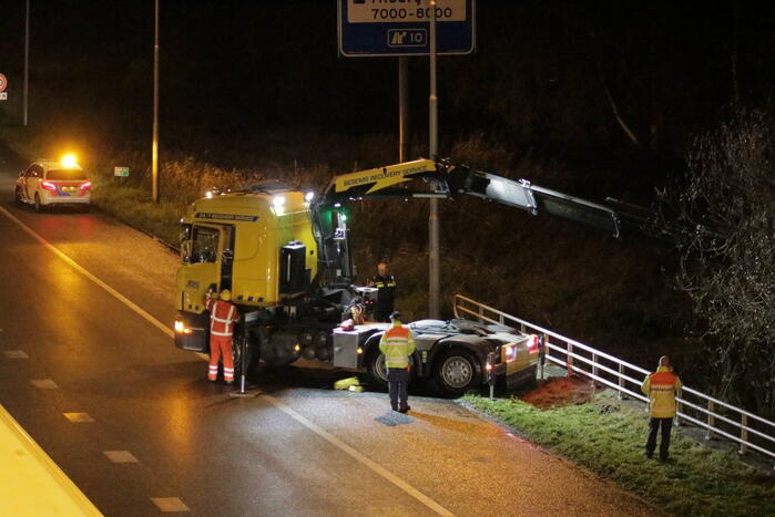 Auto belandt in water naast snelweg