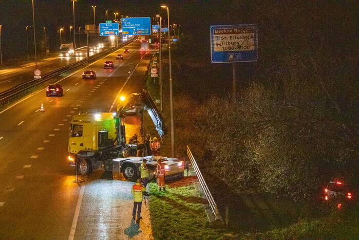 Auto belandt in water naast snelweg