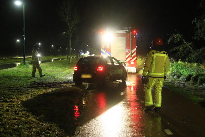 Brandweer trekt ambulance en auto uit modder