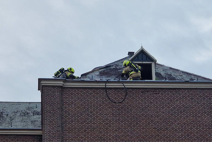 Brandweer blust brand op dak van Kapel