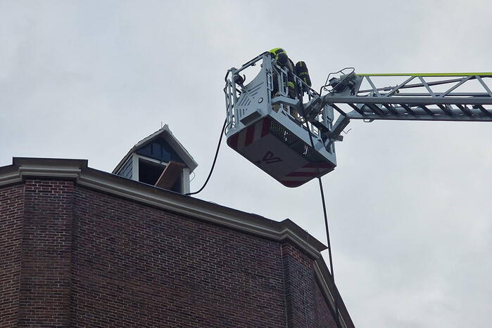 Brandweer blust brand op dak van Kapel