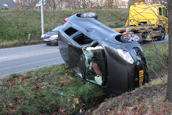 Auto op zijn kop na aanrijding met vrachtwagen