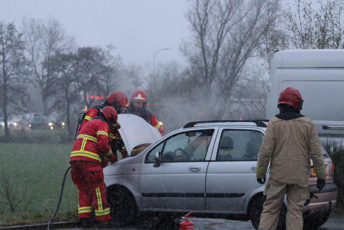 Brandweer blust brandend voertuig