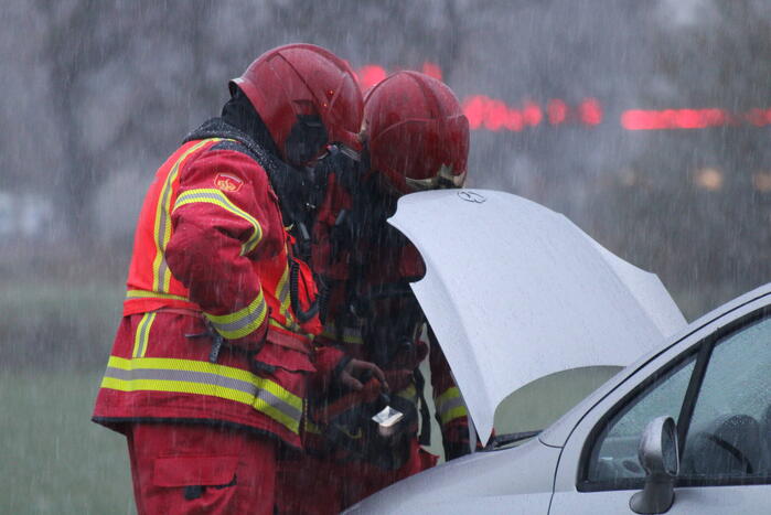 Brandweer blust brandend voertuig