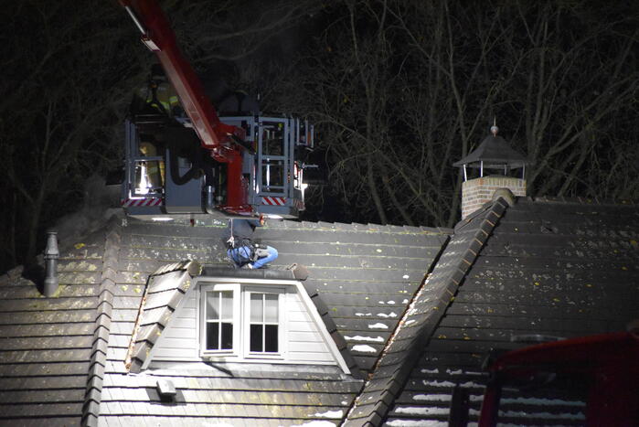 Persoon op dak van woning