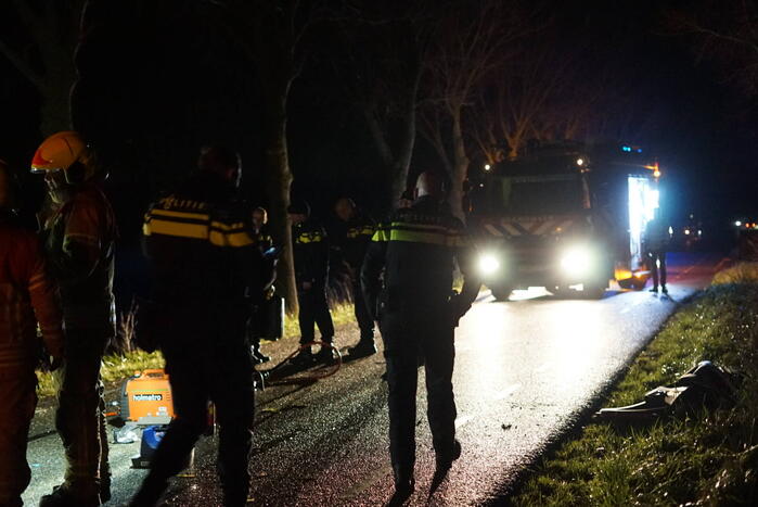 Auto zwaar beschadigd na frontale botsing tegen boom, bestuurder zwaargewond