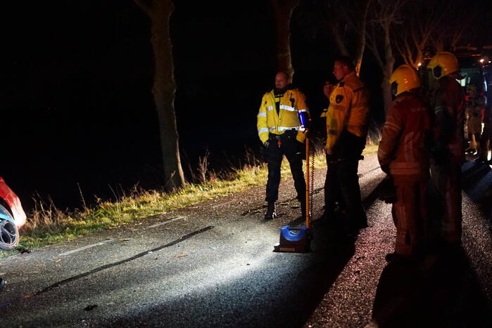 Auto zwaar beschadigd na frontale botsing tegen boom, bestuurder zwaargewond