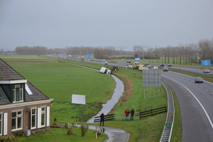 Vrachtwagen gekanteld in sloot naast snelweg