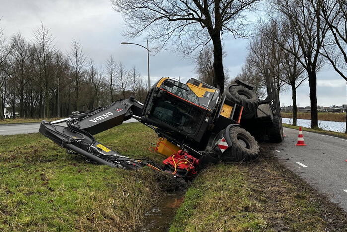 Graafmachine kantelt en komt in sloot terecht