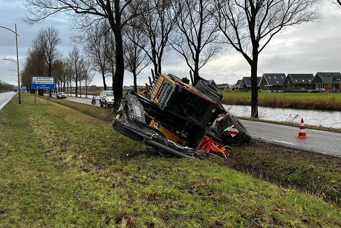 Graafmachine kantelt en komt in sloot terecht