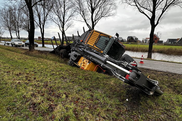 Graafmachine kantelt en komt in sloot terecht