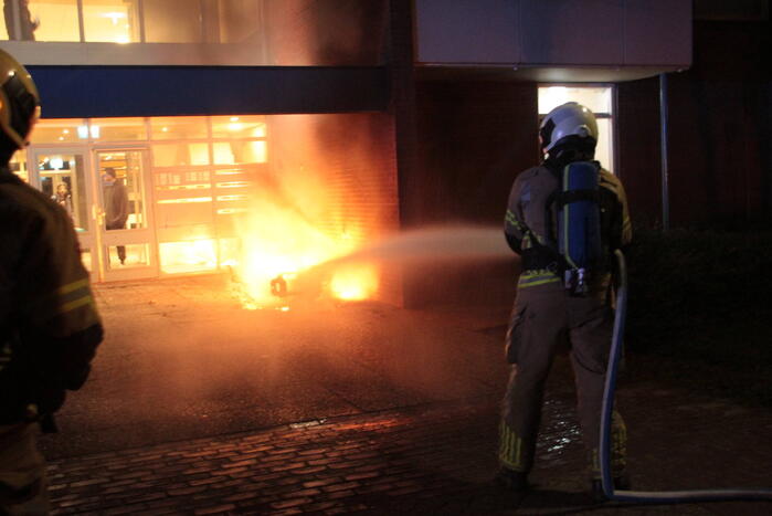 Brandweer blust brandende scooter tegen appartementencomplex
