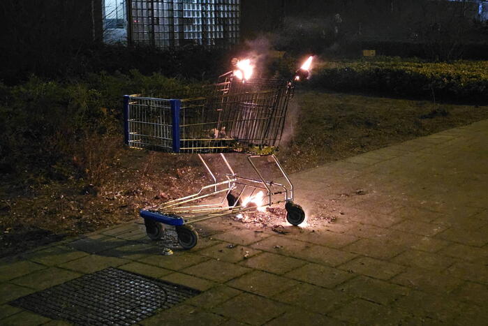 Winkelwagen met afval in brand gestoken