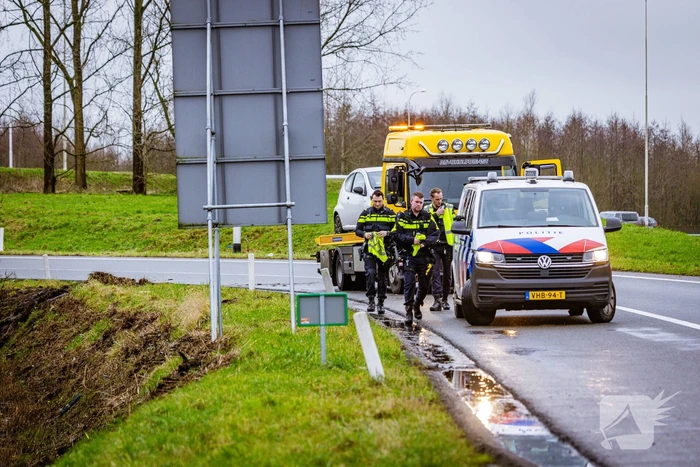 Auto raakt van de weg in bocht van afrit