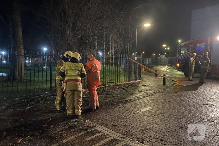 Omgevallen boom valt op hekwerk en blokkeert weg