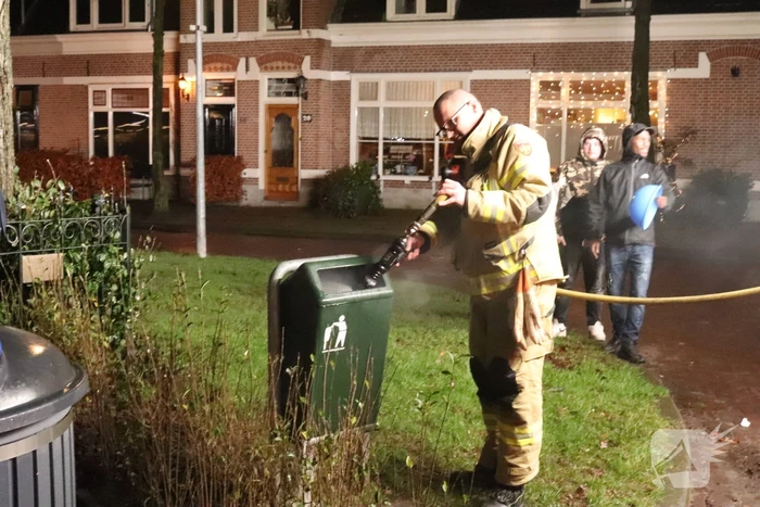 Brandweer blust brand in prullenbak
