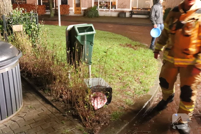 Brandweer blust brand in prullenbak