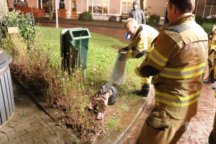 Brandweer blust brand in prullenbak