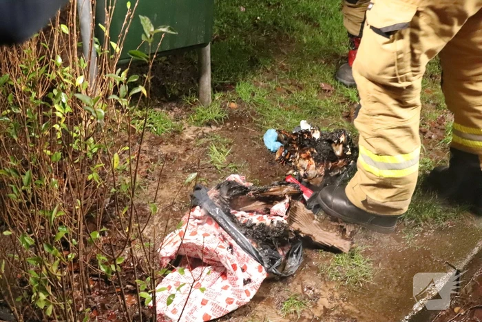 Brandweer blust brand in prullenbak