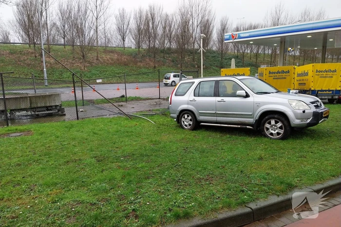 Automobilist rijdt door hekwerk van tankstation