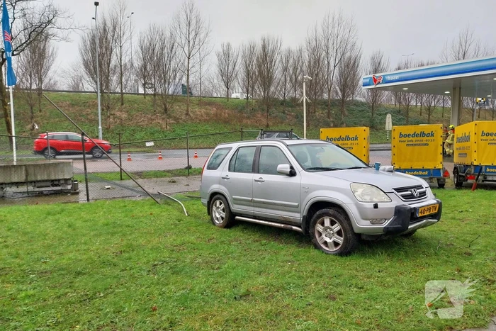 Automobilist rijdt door hekwerk van tankstation
