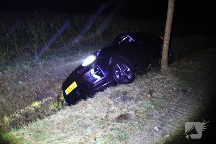 Spekglad wegdek, automobilist belandt in greppel