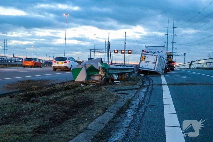 Bestelbus met aanhanger belandt op zijkant