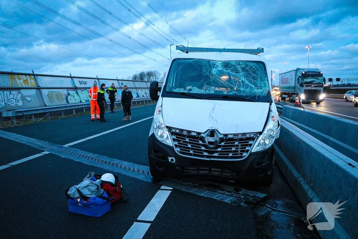 Bestelbus met aanhanger belandt op zijkant