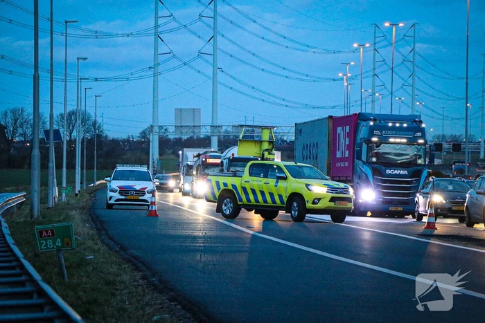 Bestelbus met aanhanger belandt op zijkant