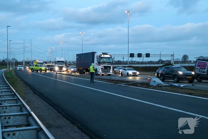 Bestelbus met aanhanger belandt op zijkant