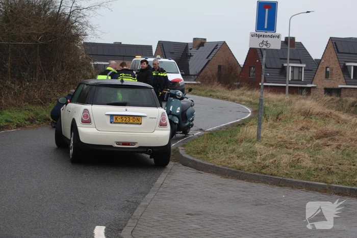 Scooterrijder schrikt van auto en gaat onderuit