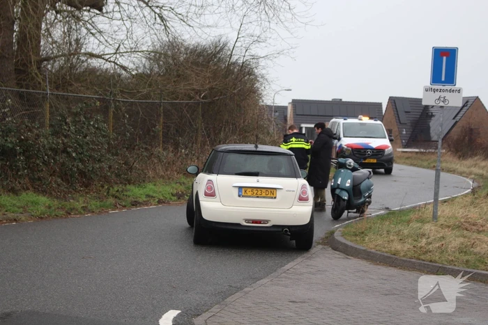 Scooterrijder schrikt van auto en gaat onderuit