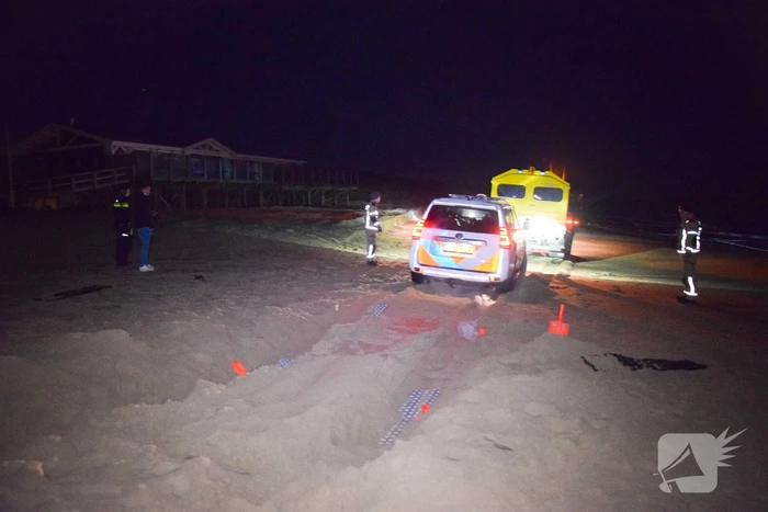 Politiejeep muurvast in los zand op strand