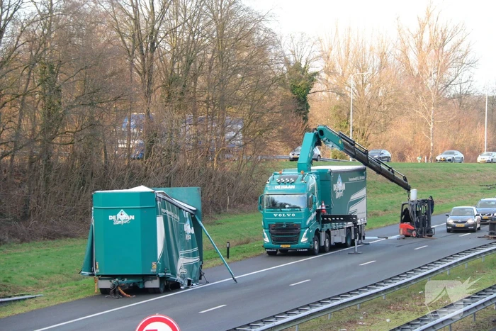 Vrachtwagen verliest twee heftrucks uit aanhanger