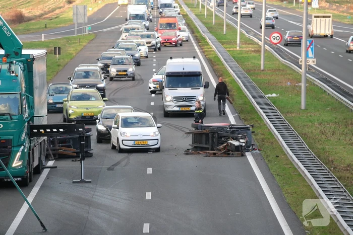 Vrachtwagen verliest twee heftrucks uit aanhanger