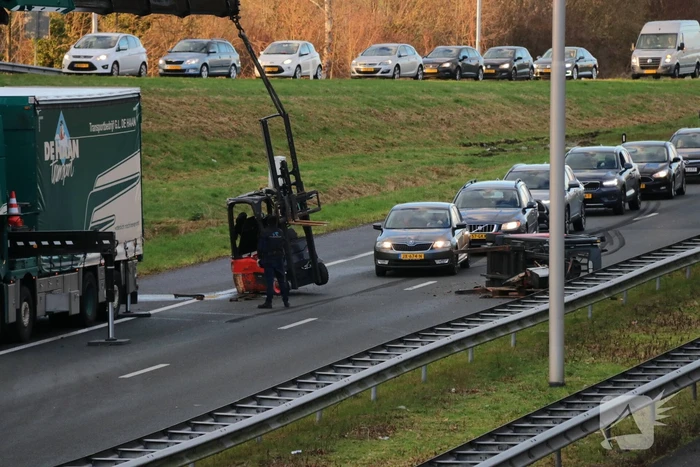 Vrachtwagen verliest twee heftrucks uit aanhanger