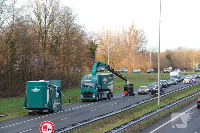 Vrachtwagen verliest twee heftrucks uit aanhanger