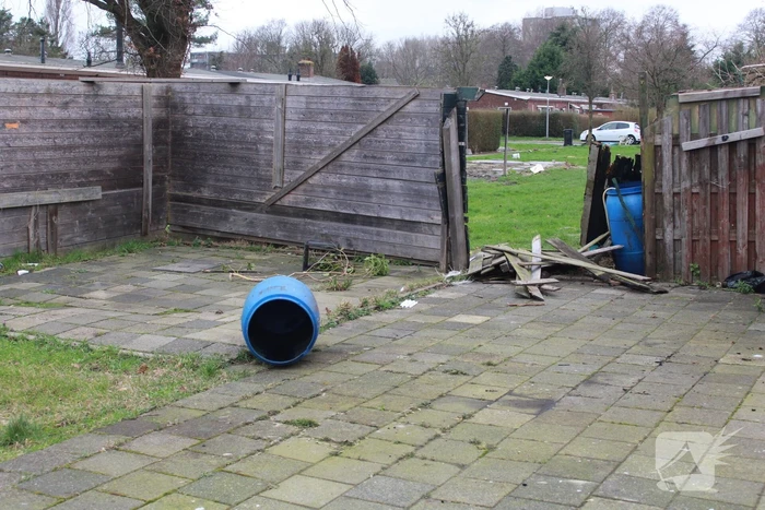 Brandweer blust brandend afval achter sloopwoningen