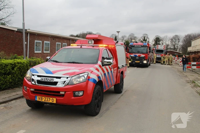 Brandweer blust brandend afval achter sloopwoningen