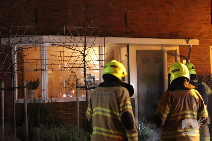 Rook in woning door smeulend hout op kachel